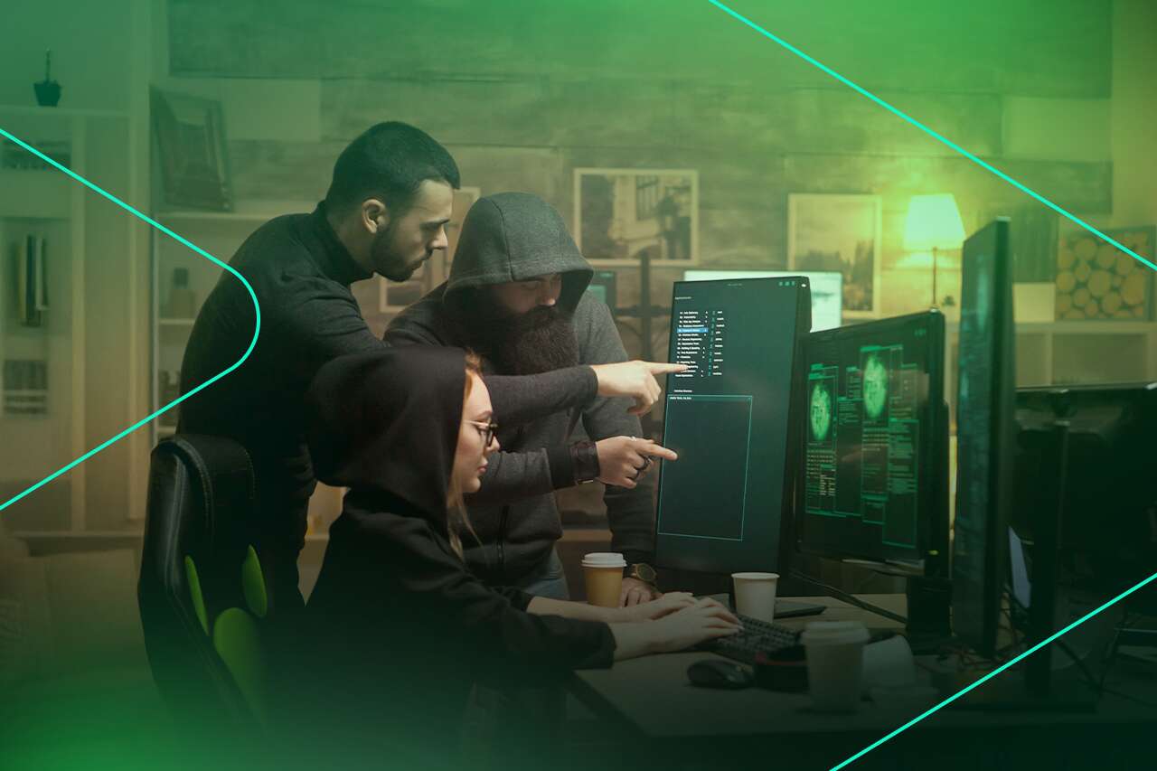 Três pessoas analisando dados em telas de computador