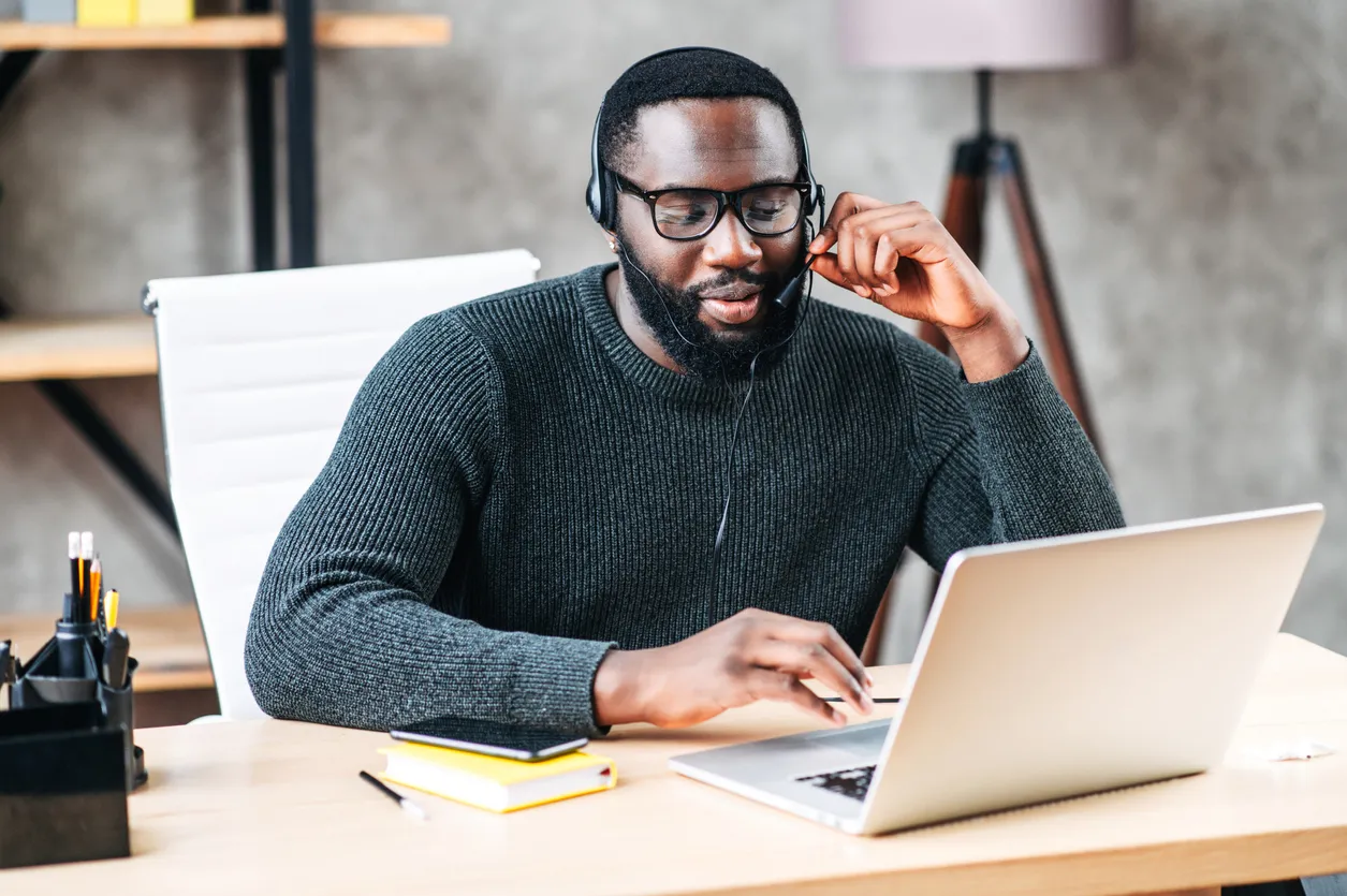 African American guy with headset using laptop