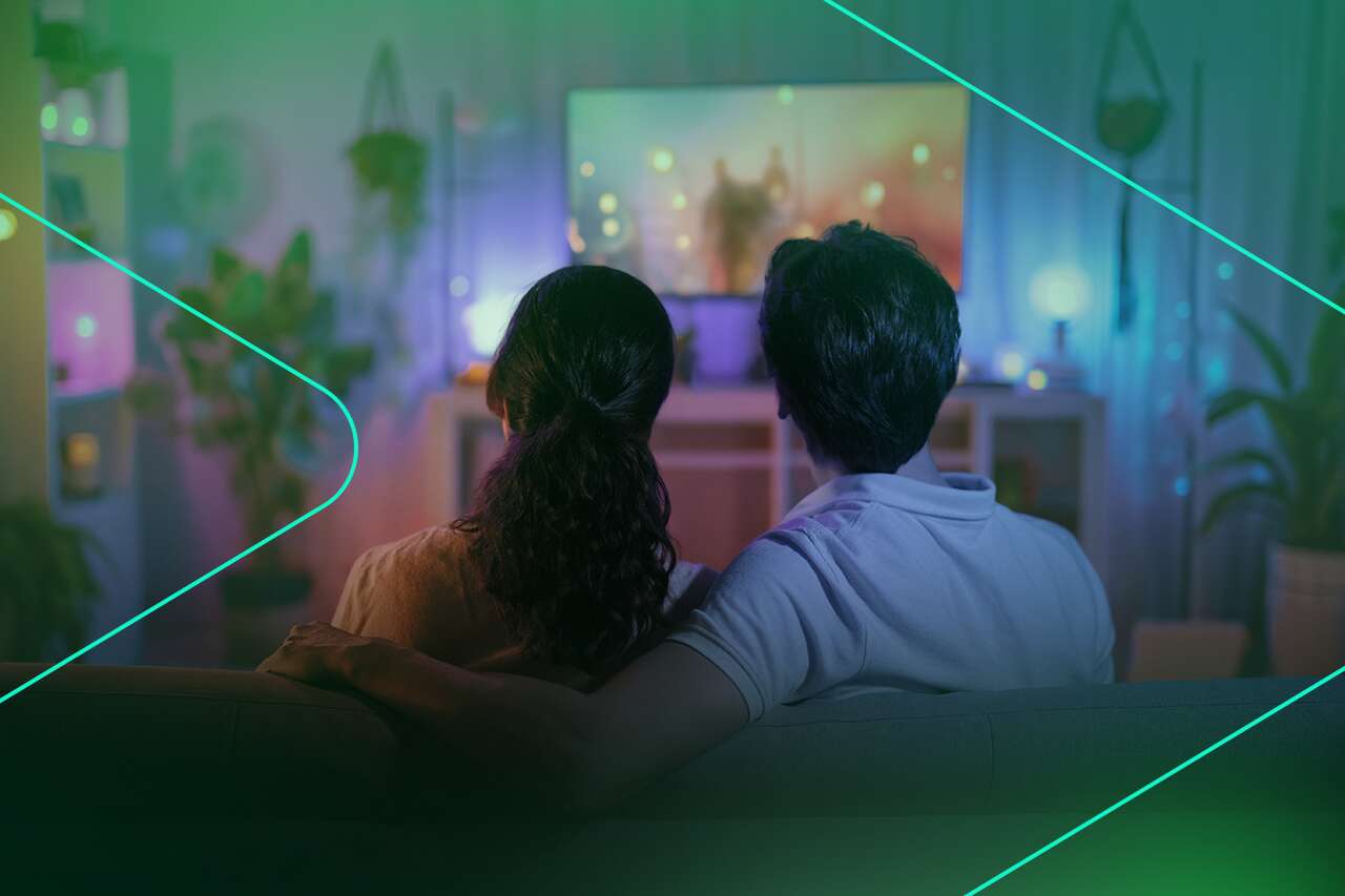 Casal assistindo TV em ambiente aconchegante