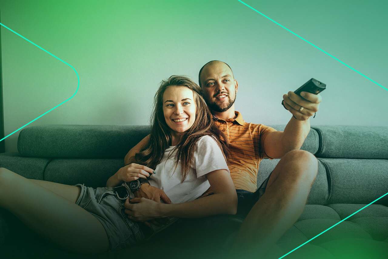 Casal relaxando no sofá assistindo televisão