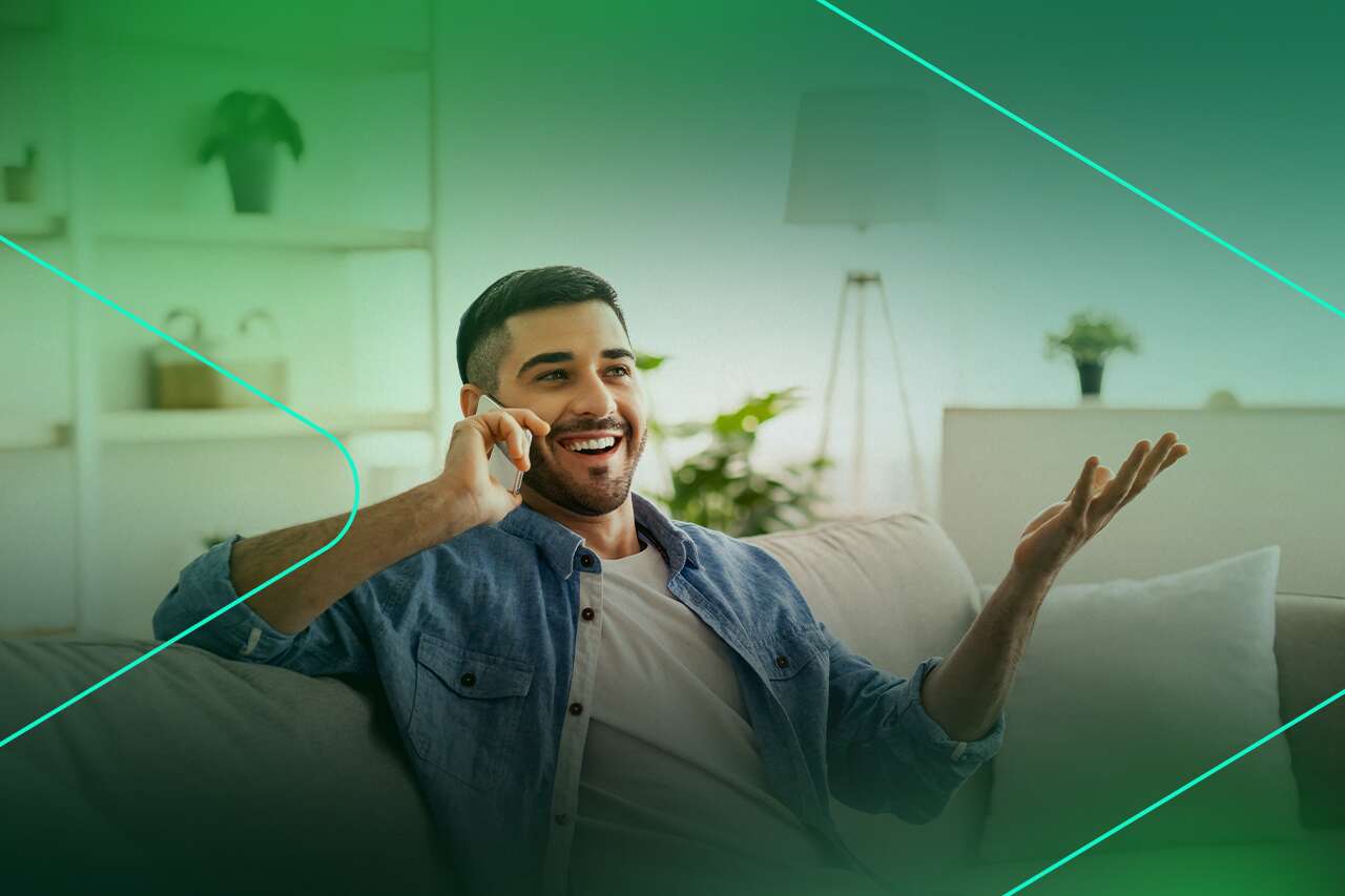 Homem sorridente conversando ao telefone em casa