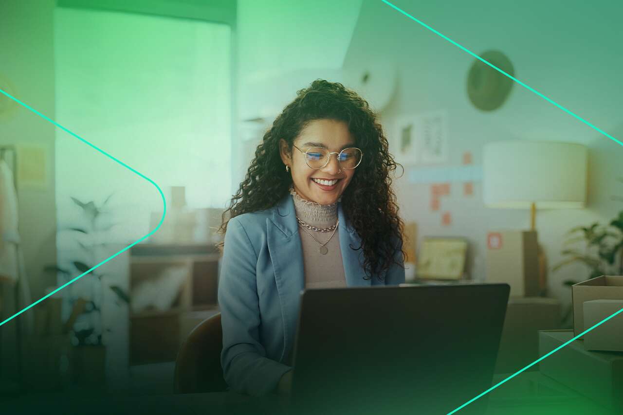 Mulher sorrindo enquanto trabalha no computador