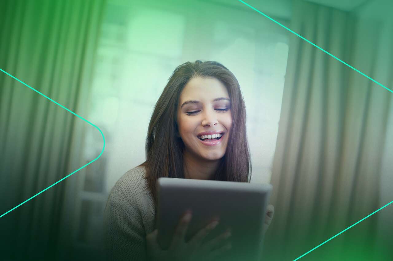 Mulher sorrindo enquanto usa um tablet
